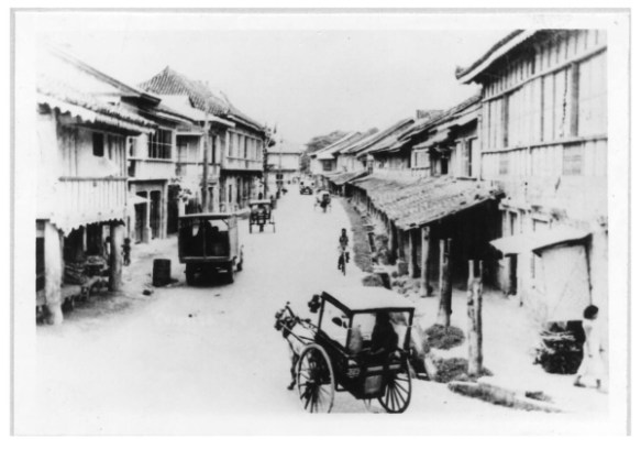 Vintage photo of a Colon Street in Cebu City, Philippines, circa 1910. A couple horse and buggies and a few people can be seen.